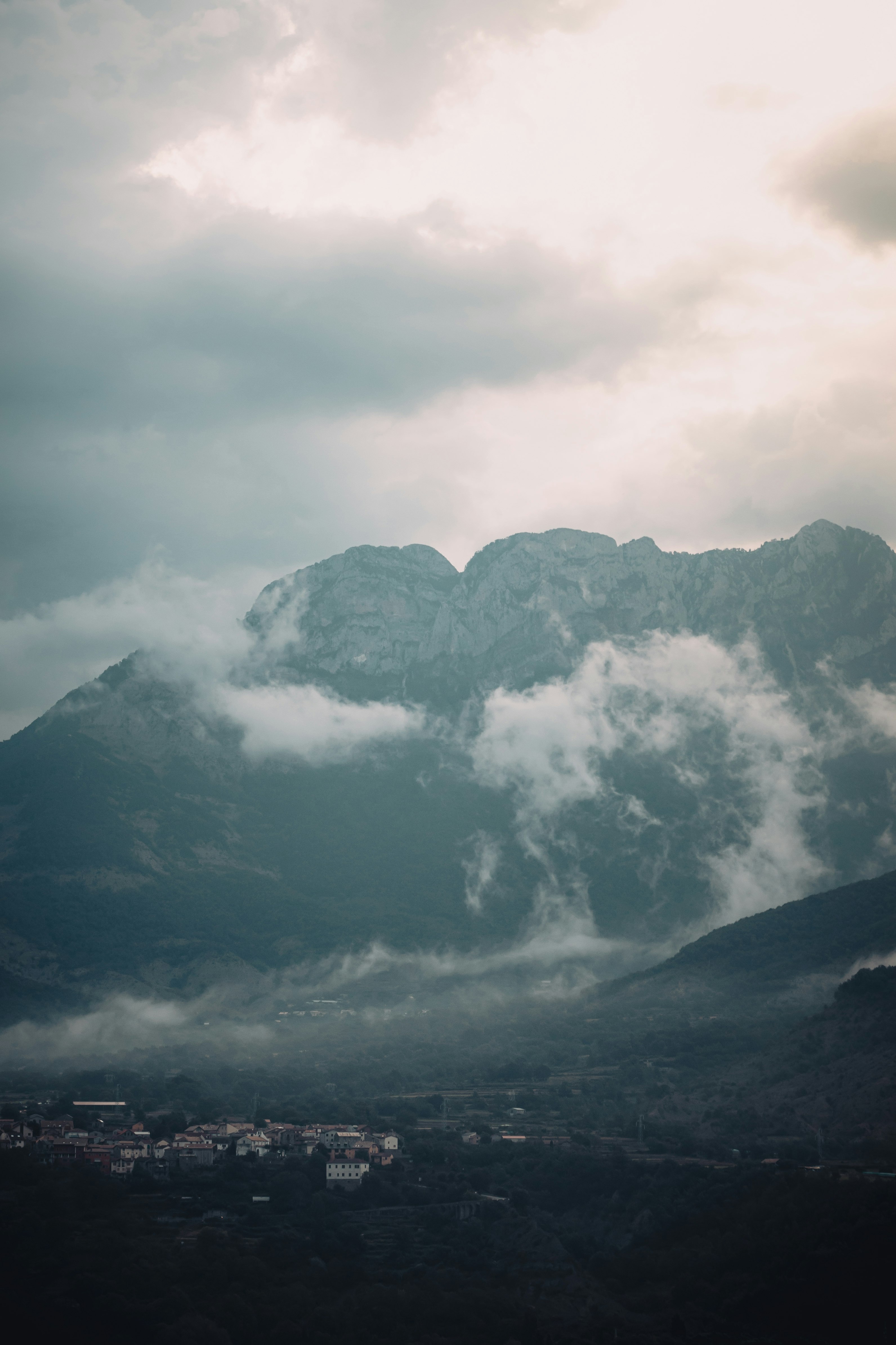 black and white mountain under white clouds